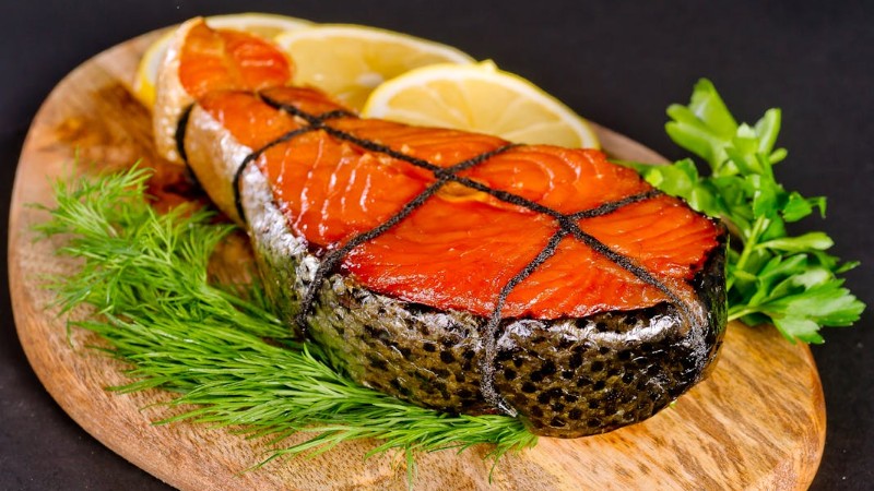 Delicious grilled salmon steak served with fresh herbs and lemon slices on a wooden board., tags: om het te - pexel
