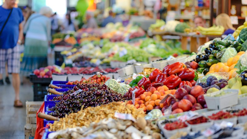 Colorful assortment of fresh fruits and vegetables in a bustling outdoor market scene., tags: van verse - pexel